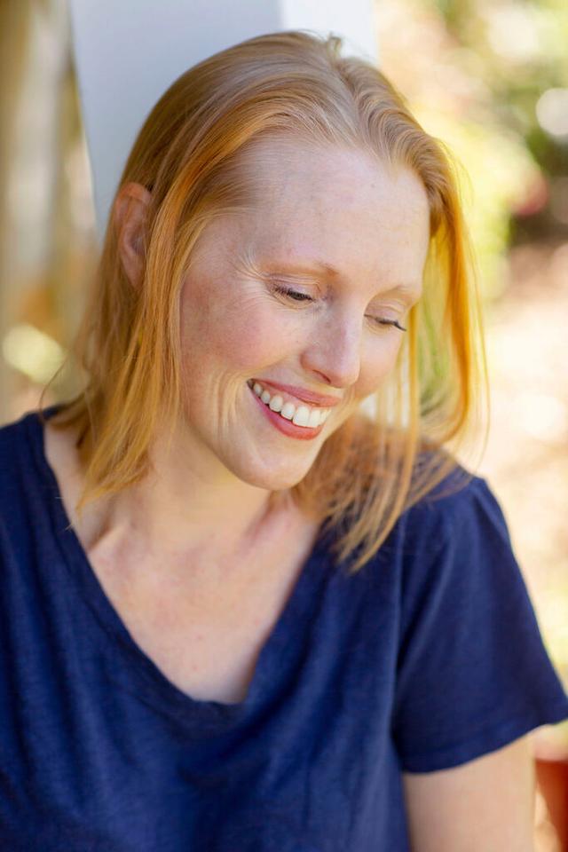 A headshot of Ashley Shew, smiling and looking away from the camera